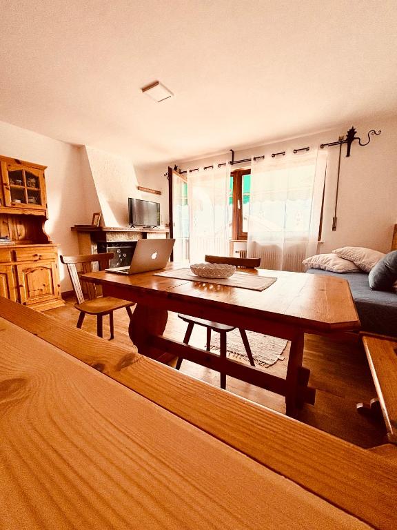 a living room with a table with a laptop on it at Apartment Fiemme Valley in Carano