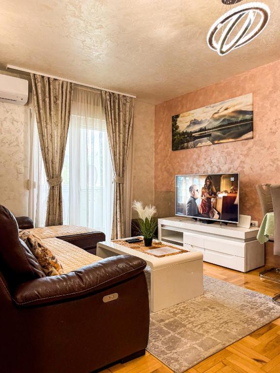 a living room with a couch and a tv at Lux Deluxe Apartment in Žabljak