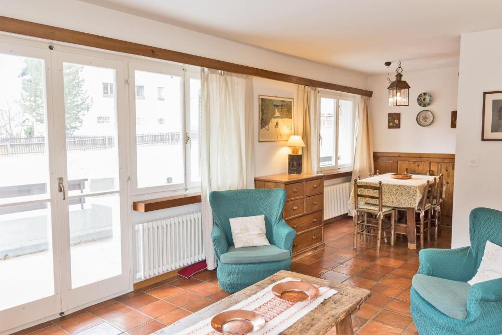a living room with blue chairs and a table at Chesa Michela - Champfer in Champfer