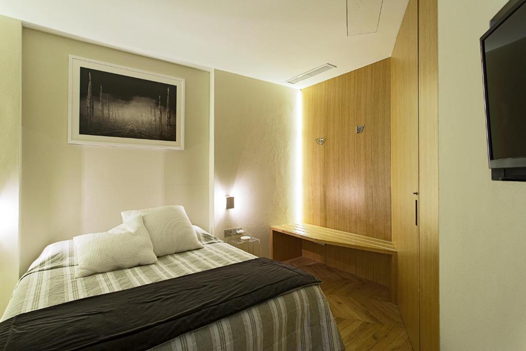 pokój hotelowy z łóżkiem i telewizorem z płaskim ekranem w obiekcie Maison Laghetto - Apartment Suite w Mediolanie