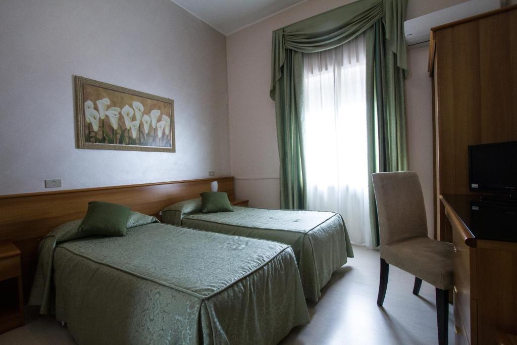 Postel nebo postele na pokoji v ubytování Hotel Adriano