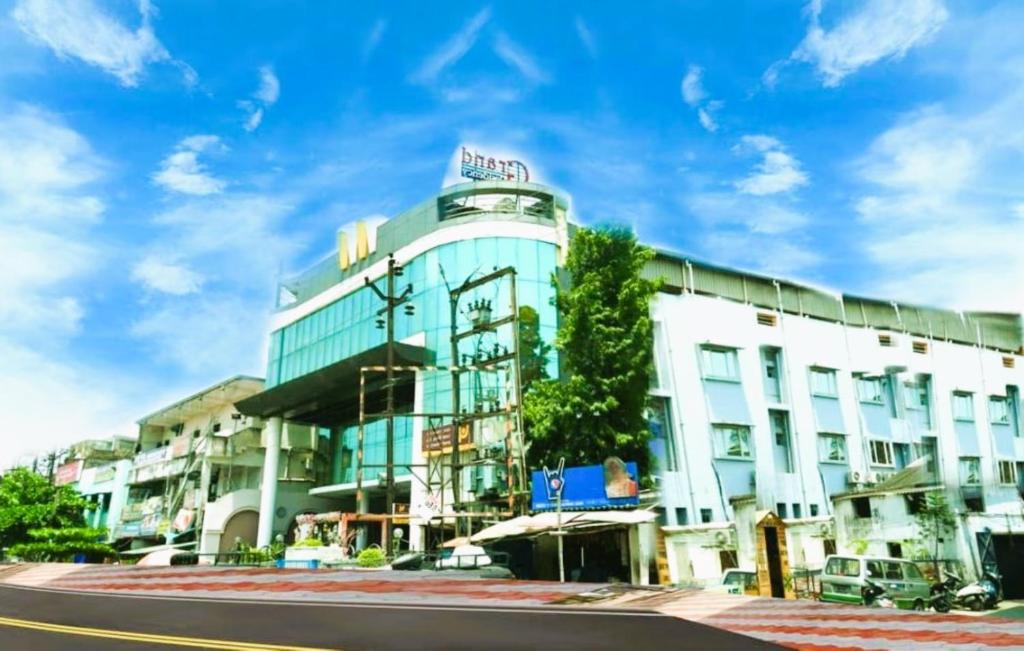 a white building on a street with a blue sky at Grand Residency Cuttack in Cuttack