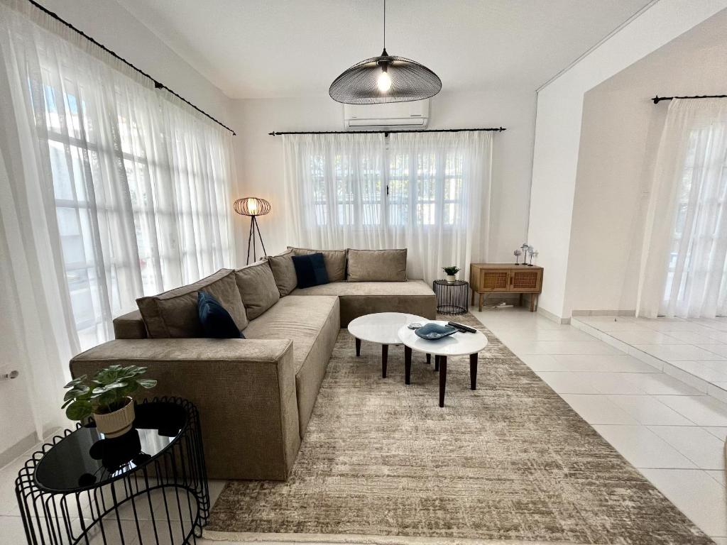 STAY Cavo Bay Villa في بروتاراس: غرفة معيشة بها أريكة وطاولة