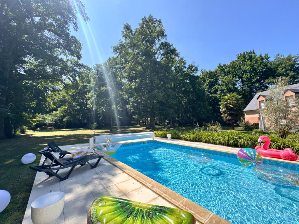 une piscine dans le jardin avec une fontaine à eau dans l'établissement Villa Nausicaa - Circuit des 24h du Mans - Piscine, à Arnage