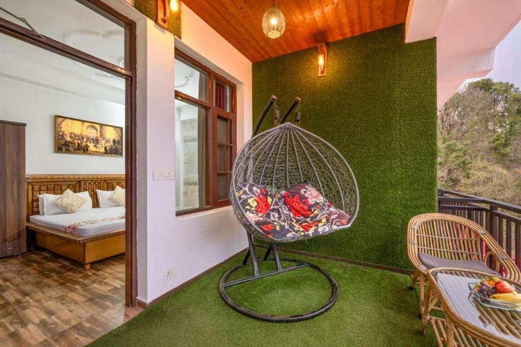 a room with a bird cage on a green wall at The Heritage Village Kasauli by Splendid Hotels in Kasauli