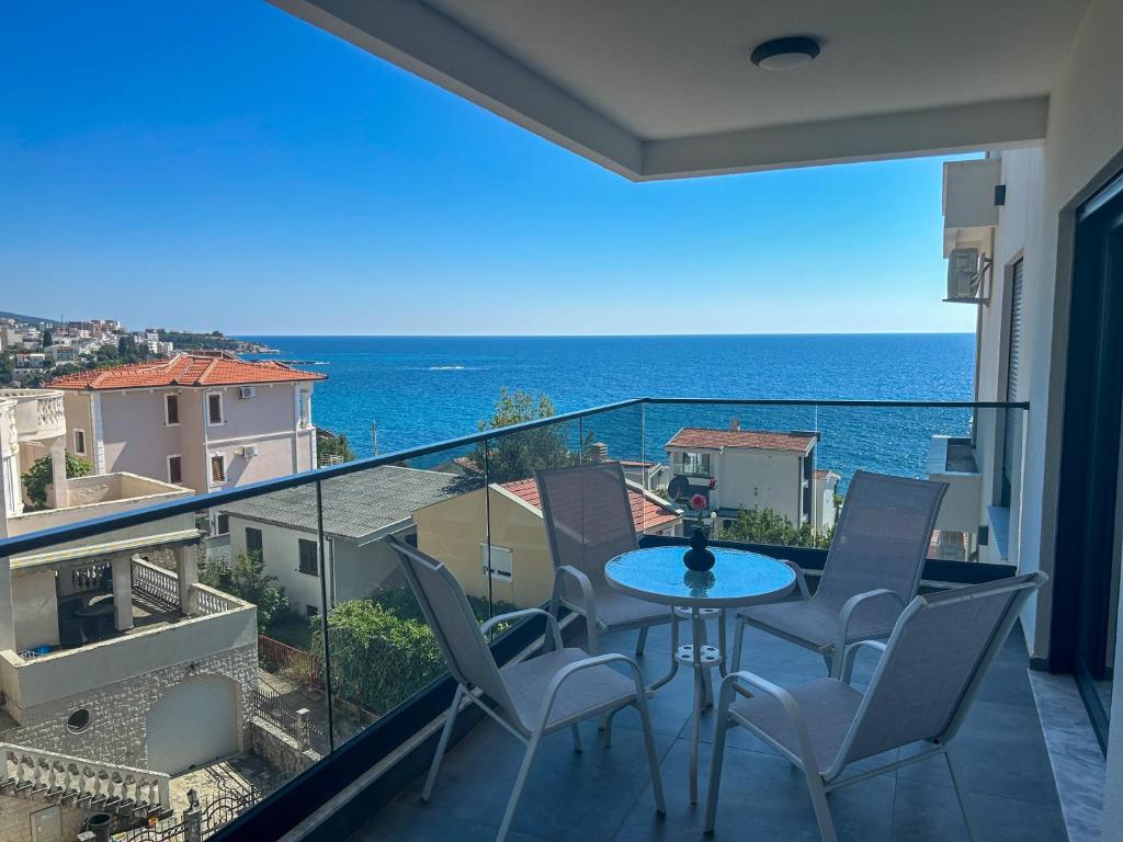 a balcony with a table and chairs and the ocean at Sea & Stone Edge Suites in Dobra Voda