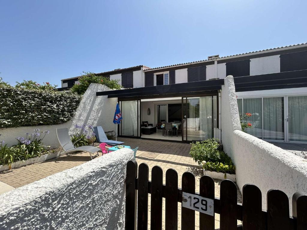 une maison avec une clôture devant dans l'établissement Maison avec véranda, proche océan, 3 chambres, parking privé - Saint-Jean-de-Monts - FR-1-224C-276, à Saint-Jean-de-Monts