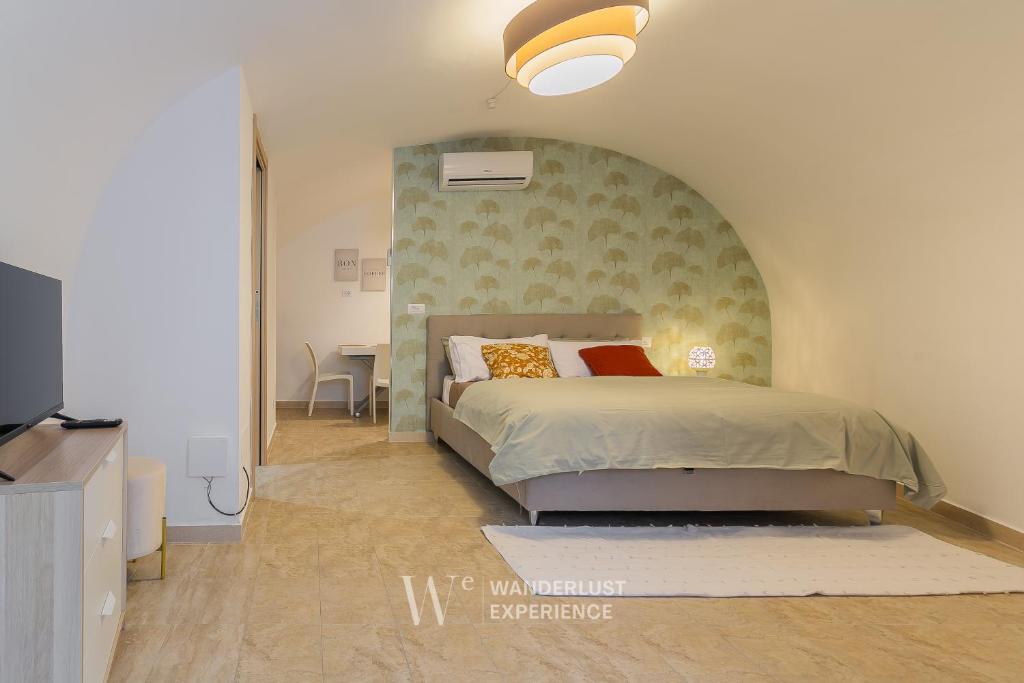 Un dormitorio con una cama grande con cabecero verde. en Wanderlust Experience Bea, en Bitonto