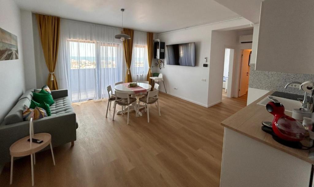 Una cocina y una sala de estar con mesa y sillas. en Yaio Penthouse, en Agigea