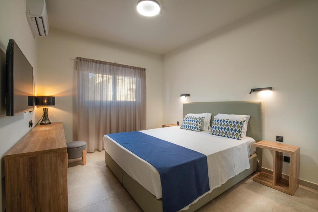 a bedroom with a large bed and a window at Amore Protaras Apartments in Paralimni