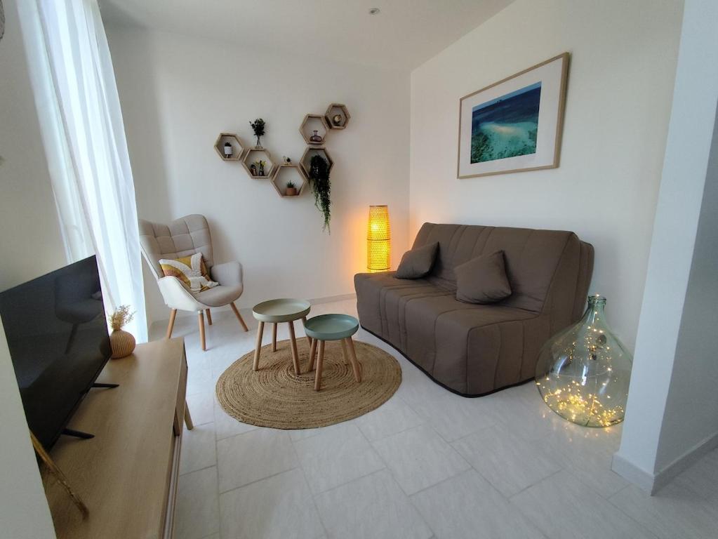 a living room with a couch and a table at Appartement cosy village entre mer et nature in Le Pradet