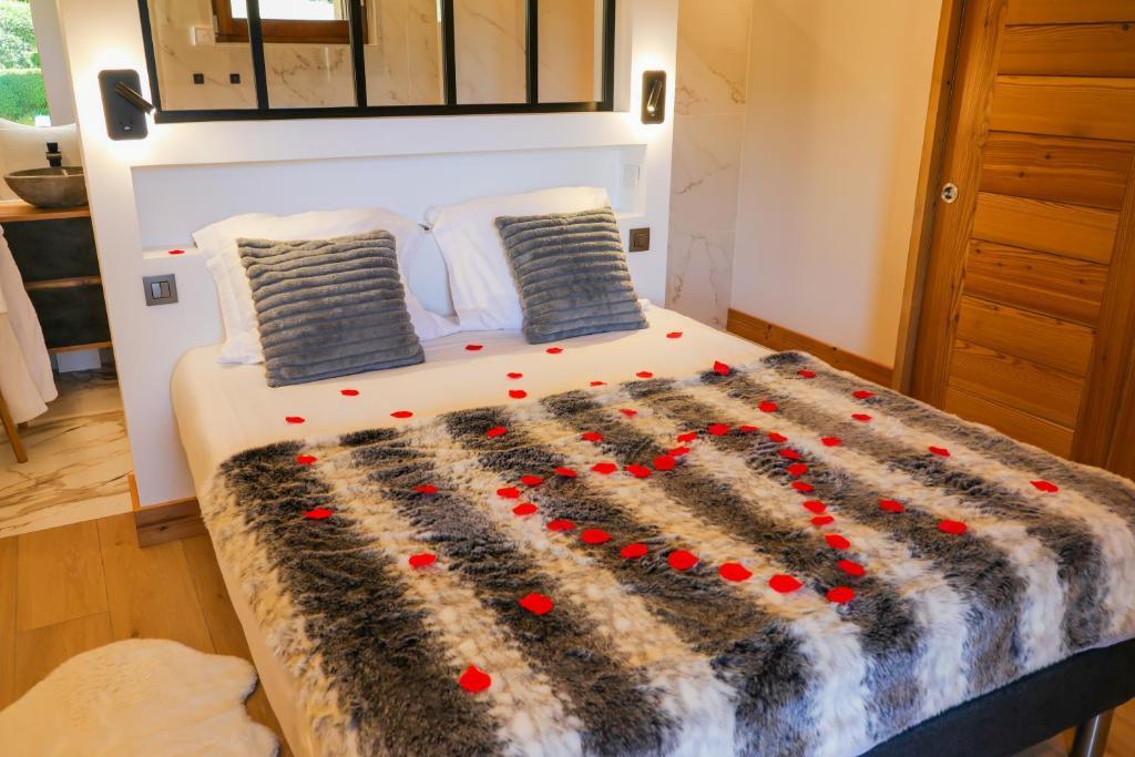 un lit avec des fleurs rouges dessus dans une chambre dans l'établissement L échappée Belle, à Megève
