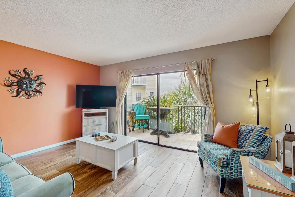 a living room with a couch and a tv at The Beach Escape in Clearwater Beach