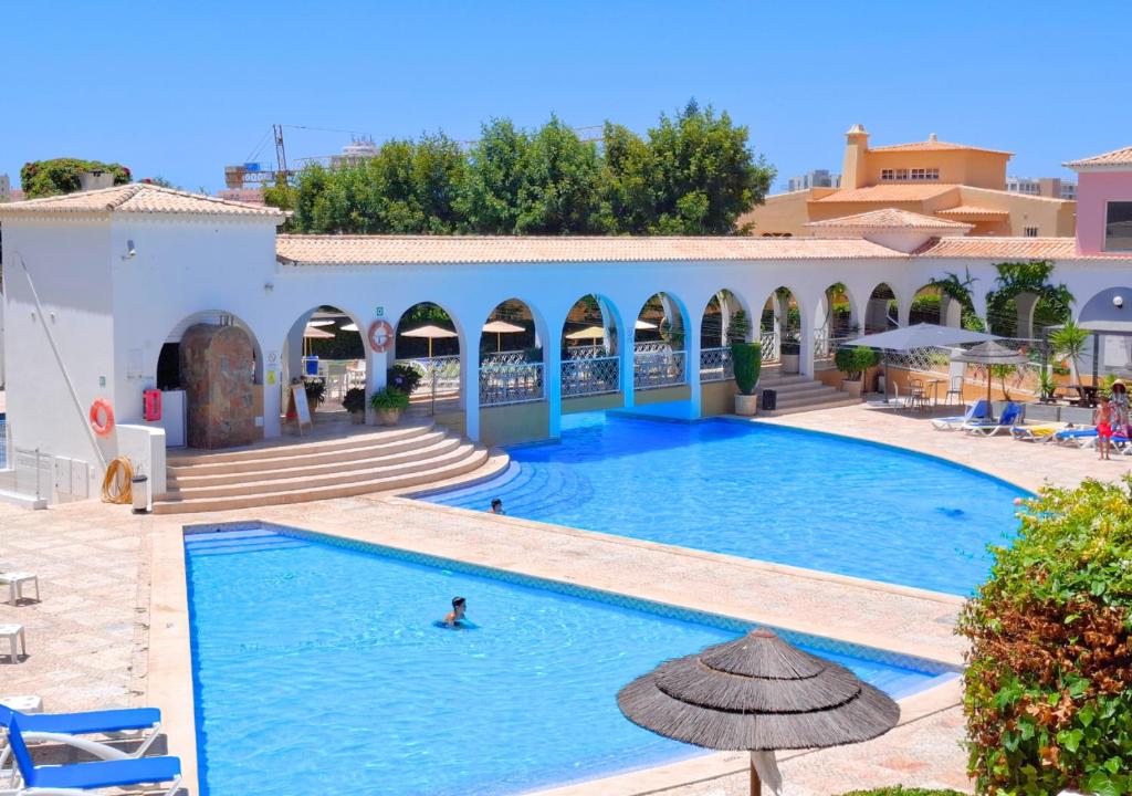 une piscine dans un complexe hôtelier avec des gens qui y nagent dans l'établissement Alltravel Vila Rosa apartment, à Portimão