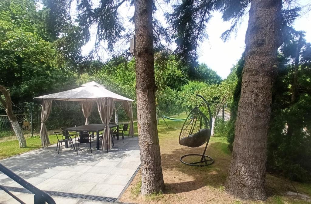 a patio with a table and umbrella and trees at Sara Resort II in Wisełka