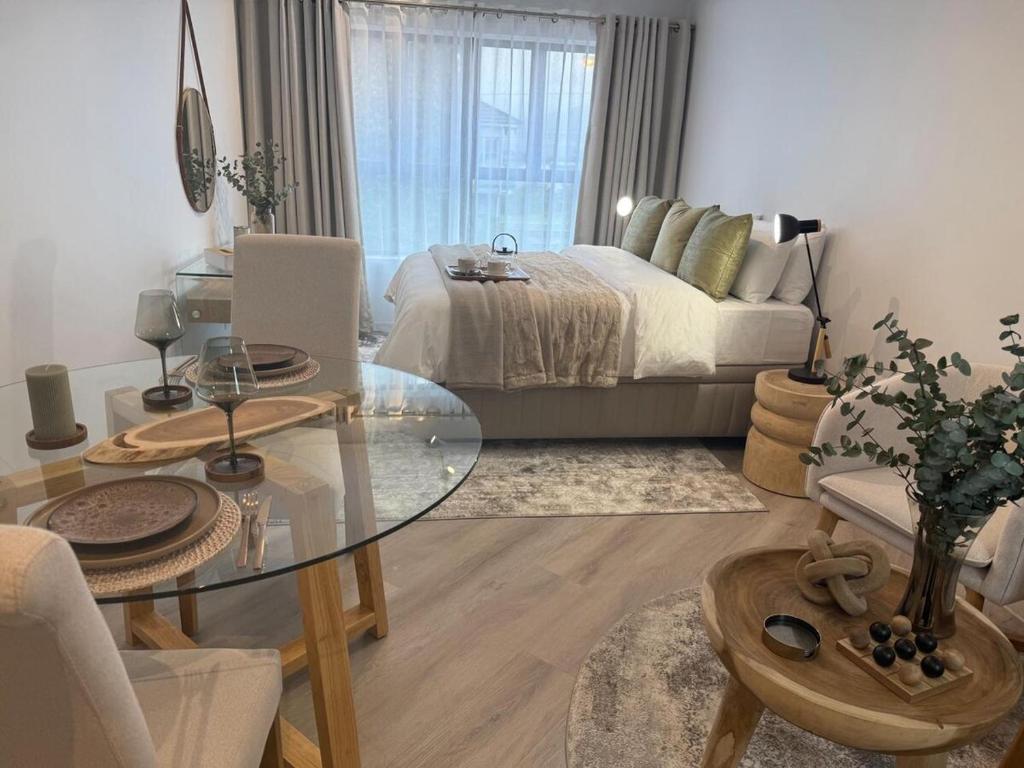 a living room with a bed and a glass table at Platform 132 - 2 On Tabak with onsite Parking in Paarl