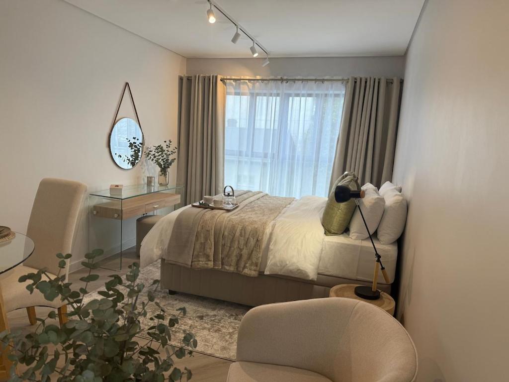 a bedroom with a bed and a desk and a chair at Platform 132 - 2 On Tabak with onsite Parking in Paarl