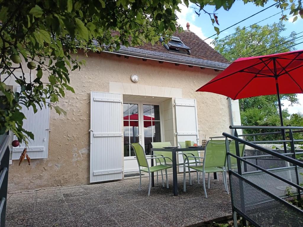 a table and chairs with a red umbrella at Mielogite in La Croix-en-Touraine