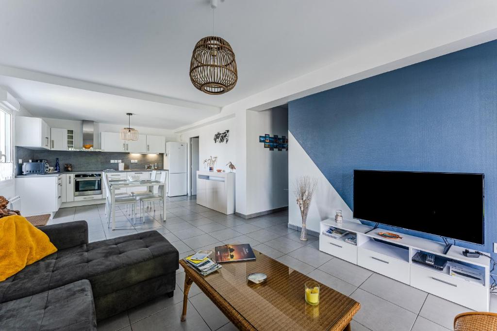 - un salon avec un canapé et une grande télévision dans l'établissement Appartement T3, Bassin D'arcachon, à Andernos-les-Bains
