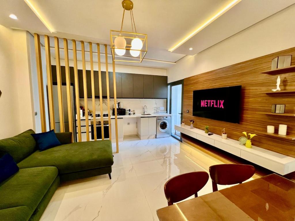 a living room with a green couch and a table at Bright Corniche Escape - 2 BR Urban Flat in Tangier