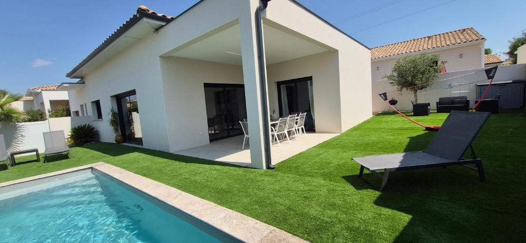 une cour avec une piscine et une maison dans l'établissement Villa REVA ,8 couchages, piscine entre terre et mer, à Nézignan-lʼÉvêque