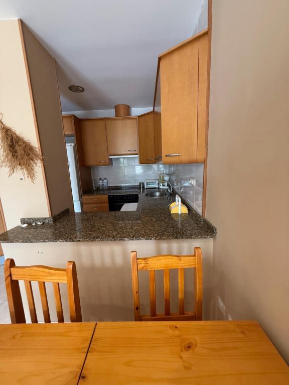 a kitchen with a table and two chairs and a counter at Apartamento Torreblanca III Ref 063 in Torrenostra