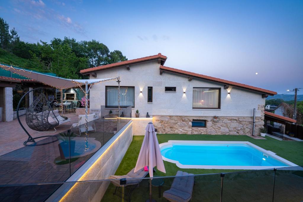 a house with a swimming pool in the backyard at Casa vacacional San Miguel in Maside