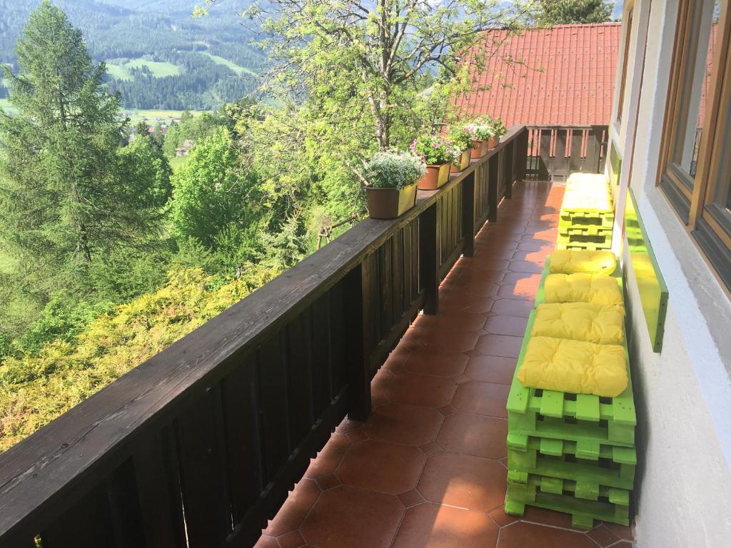 a balcony with yellow and green seats on a railing at Vila Familyparadise Bergstrasse in Sankt Michael im Lungau