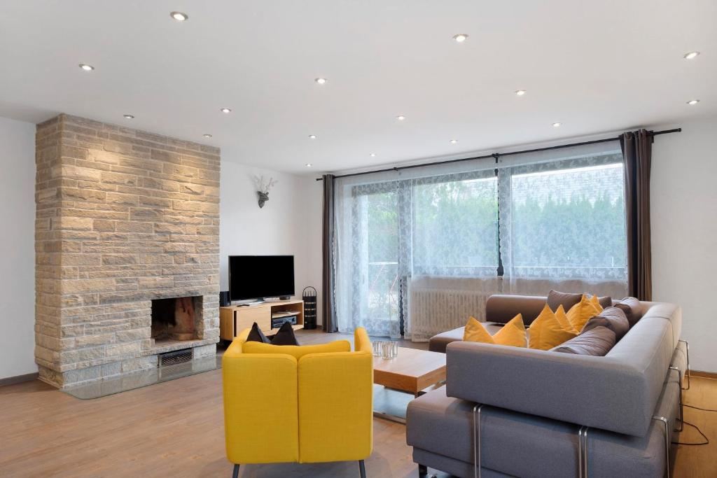 un salon avec un canapé et une cheminée dans l'établissement Ferienhaus Obergfell, 110 Qm, à Schönwald