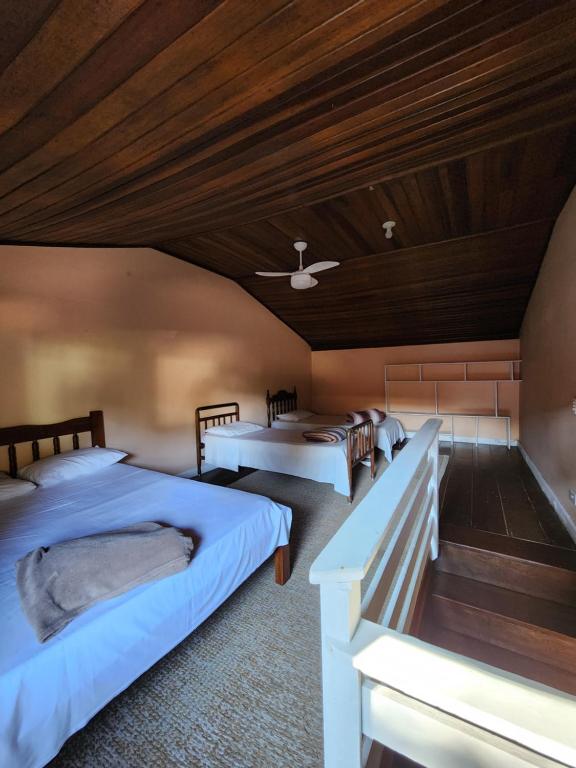 ein Schlafzimmer mit drei Betten und einer Holzdecke in der Unterkunft Hospedagem Majestade in Paraty