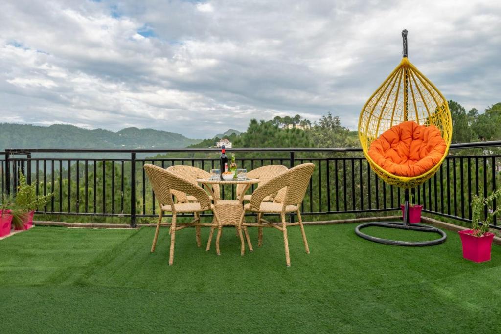 a patio with a table and chairs and a swing at Exotic Stays I The Mountains Vibes I Food & Free Parking Available I Family Events Allowed I Kasauli in Kasauli