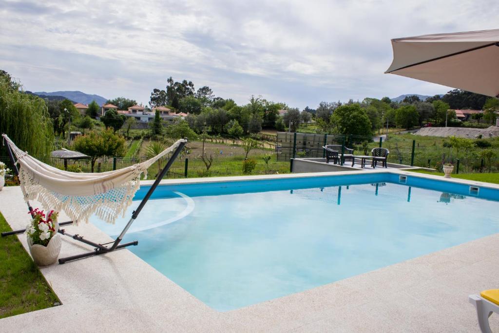 蓬蒂達巴爾卡的住宿－Escondidinho do Vez, LDA，游泳池旁的吊床