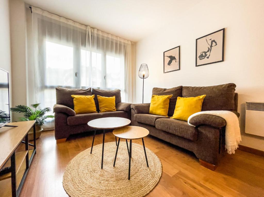 a living room with a couch and two tables at Refugio Ceretà Naturaleza, Aventura y Confort in Alp
