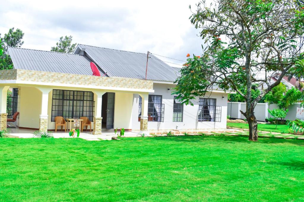 a house with a green lawn in front of it at Luxury Peace House in Arusha