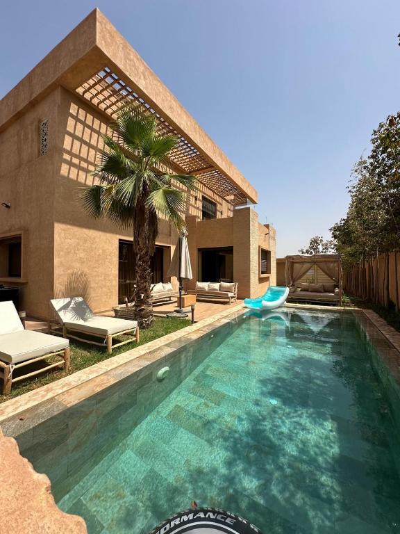 a swimming pool in front of a house at Villa familiale a 10km du boulevard Mohamed VI in Marrakesh