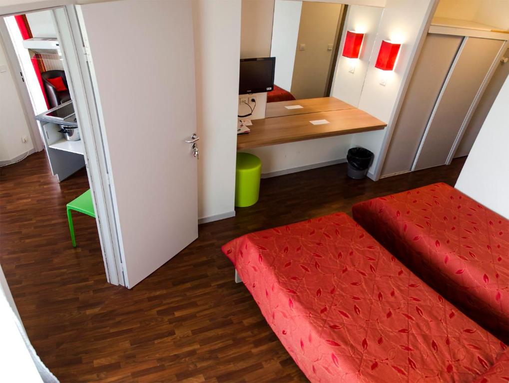 a small room with a red bed and a desk at VVF Urrugne Saint-Jean-de-Luz Côte Basque in Urrugne