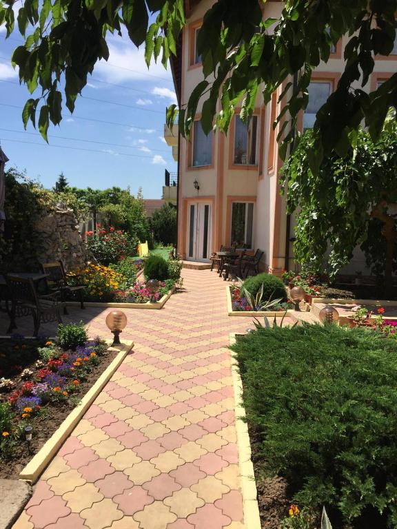 a walkway in front of a building with flowers at Vila OK2 in Costinesti
