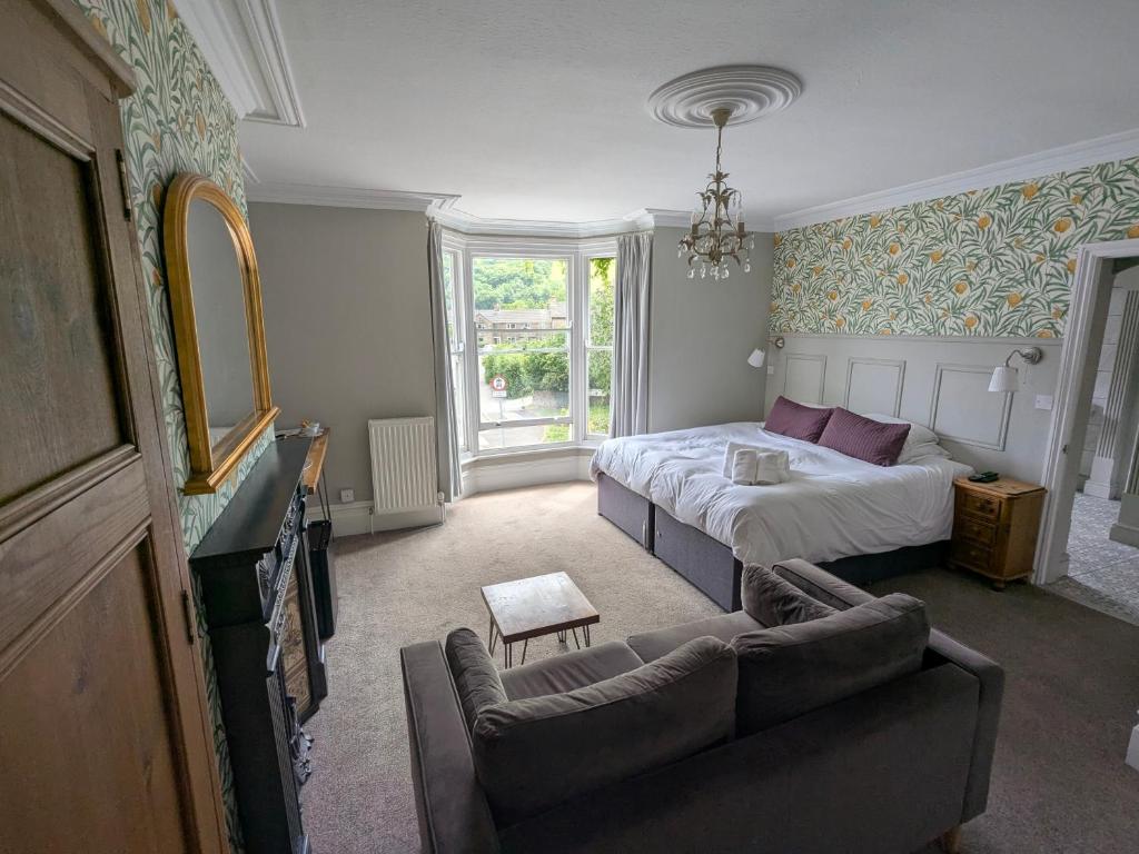 a hotel room with a bed and a couch at Four Seasons Guesthouse in Castleton