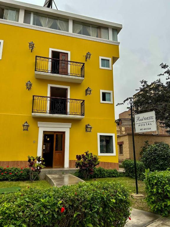 a yellow building with two balconies on it at Real Marquez in Trujillo