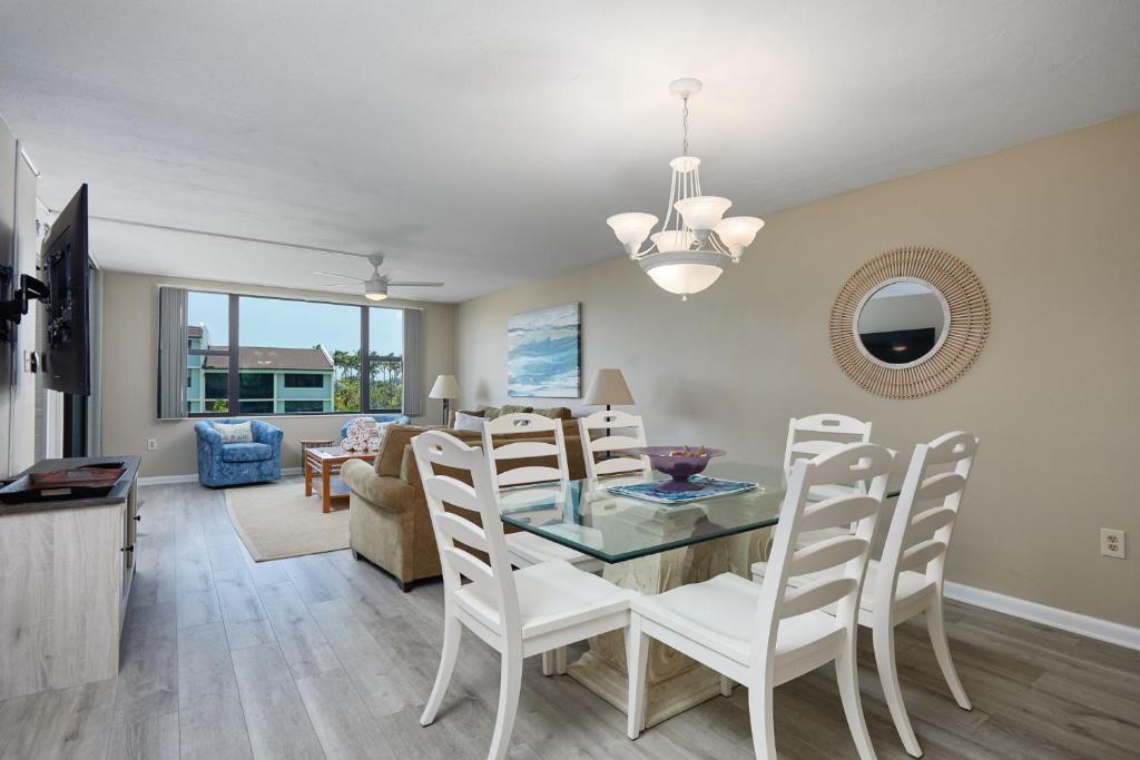 a dining room and living room with a table and chairs at Loggerhead 543 - Gorgeous Beachfront Residence at Loggerhead Cay in Sanibel