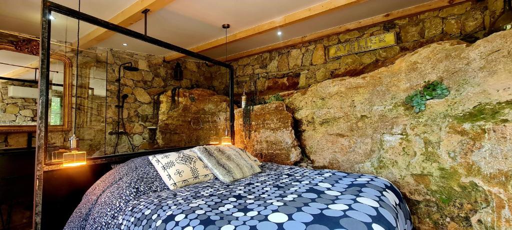 a bedroom with a bed in a stone wall at Le Masdemoiselle Mazet in Salernes