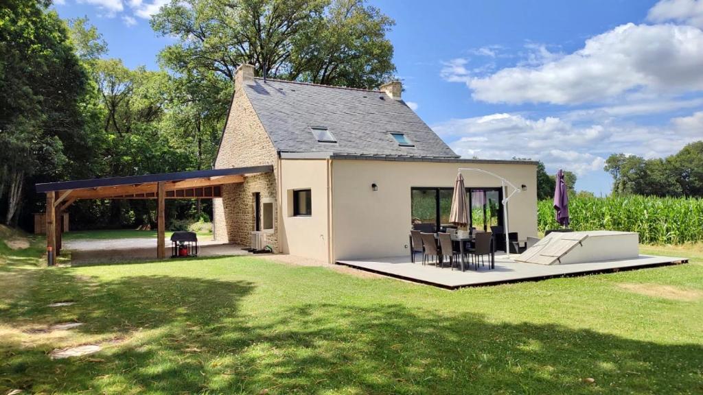 Cette petite maison blanche dispose d'une terrasse dans la cour. dans l'établissement Maison bretonne rénovée à 20 min des plages, parking privé, à Grand-Champ