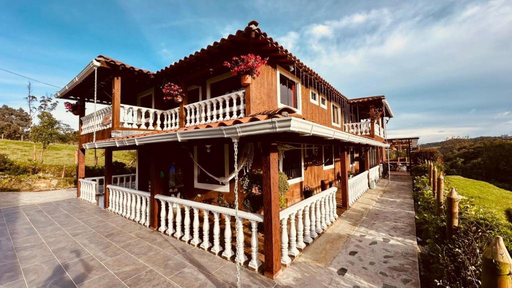 una casa de madera con porche y balcón en Finca campestre mi retoño, en Medellín