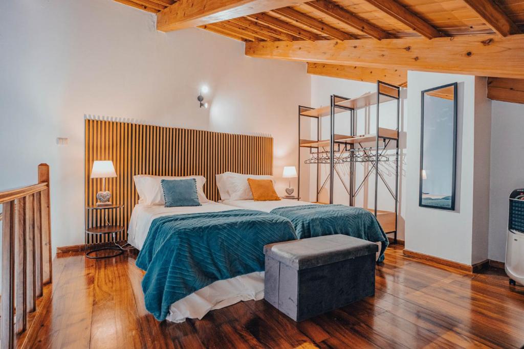 ein Schlafzimmer mit einem großen Bett in einem Zimmer mit Holzdecken in der Unterkunft Yellow House - Casa 2 in Angra do Heroísmo