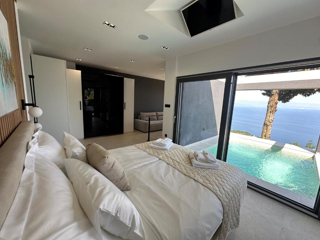a bedroom with a large white bed and a pool at Dream 1-Bedroom Villa with Heated Indoor Pool, Jacuzzi & Sauna and BBQ in Medveja