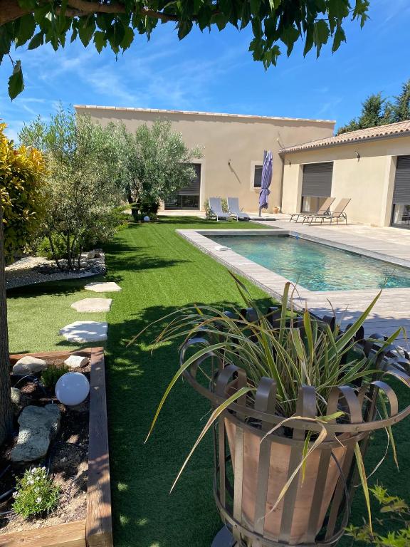 a yard with a swimming pool and a house at L instant provençal in Robion en Luberon