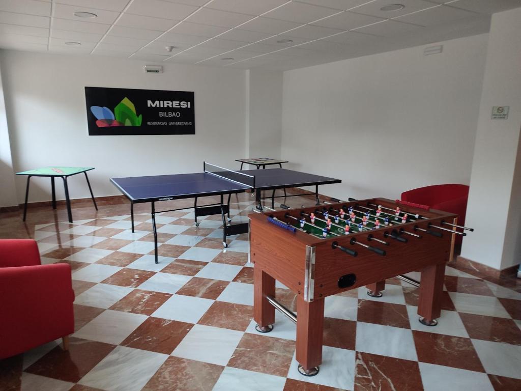 a room with two ping pong tables on a checkered floor at Miresibilbao - Residencia Universitaria in Bilbao