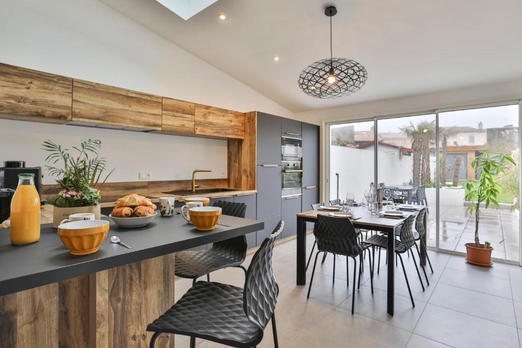 une cuisine et une salle à manger avec une table et des chaises dans l'établissement Maison proche plage présidents, à Les Sables-dʼOlonne