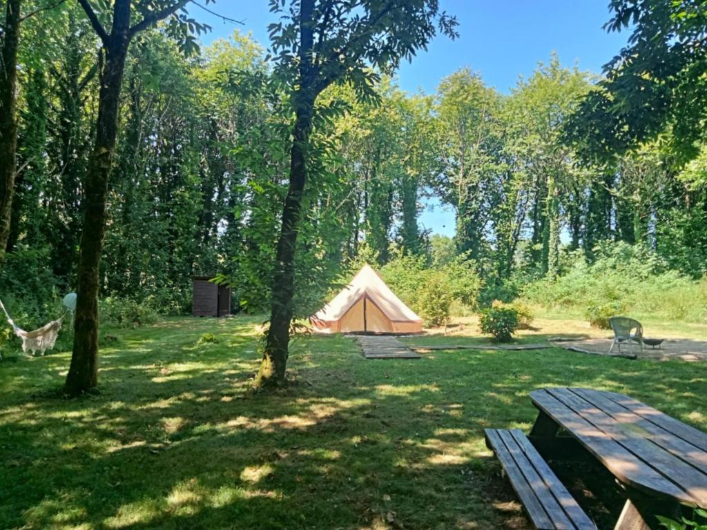 une tente au milieu d'un champ avec des arbres dans l'établissement tente nature, à Plouray