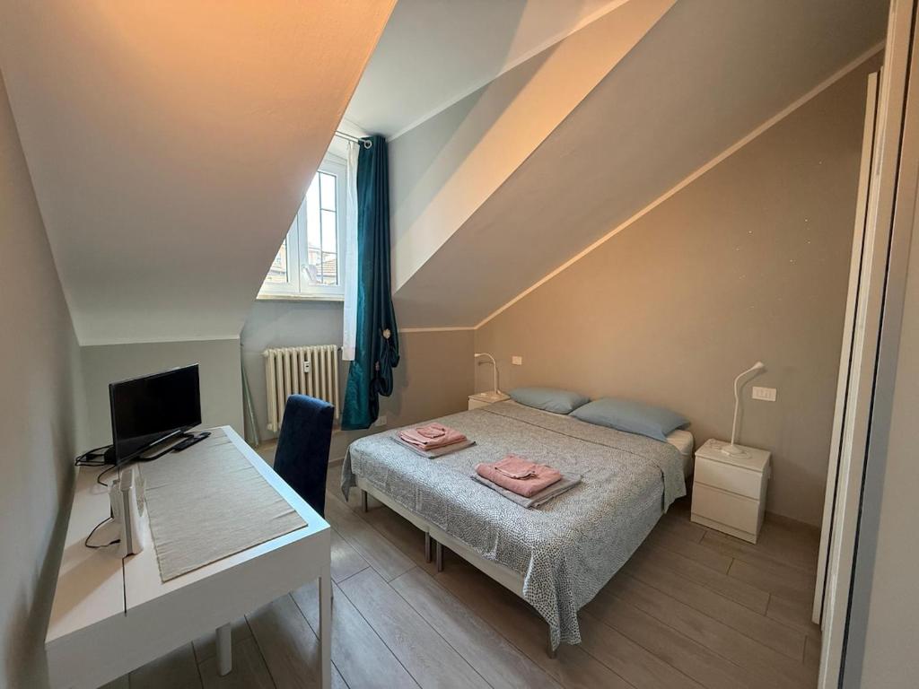 a small bedroom with a bed and a desk at Splendida mansarda nel cuore della città in Turin